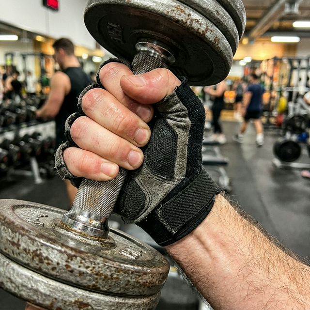 Mocny uścisk dłoni na hantlu jako symbol siły całego ciała